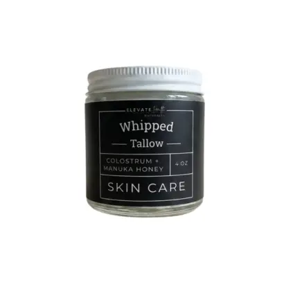 Whipped Tallow Colostrum + Manuka Honey in a clear 4oz jar with metal screw on lid